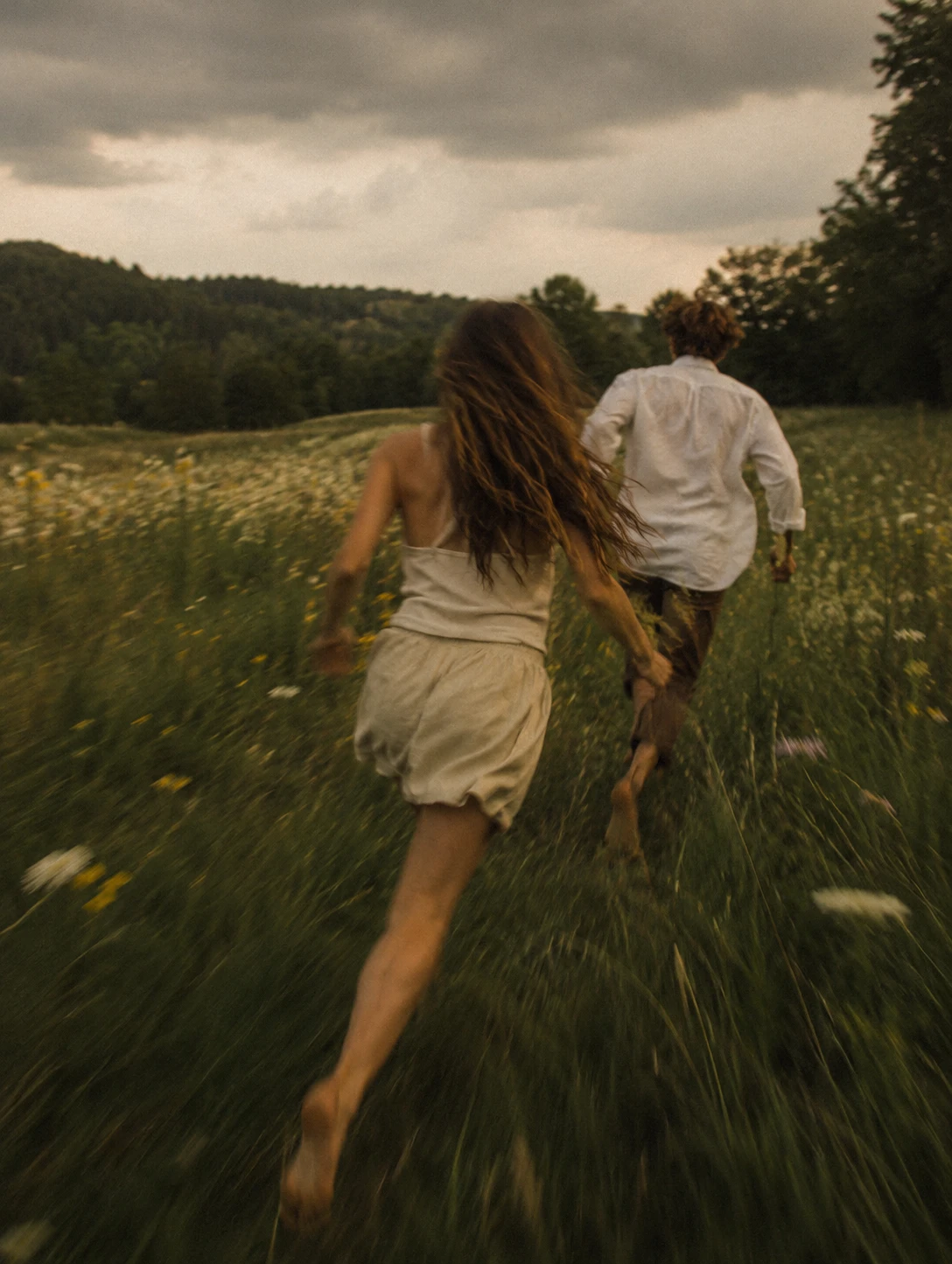 two people running through a meadow